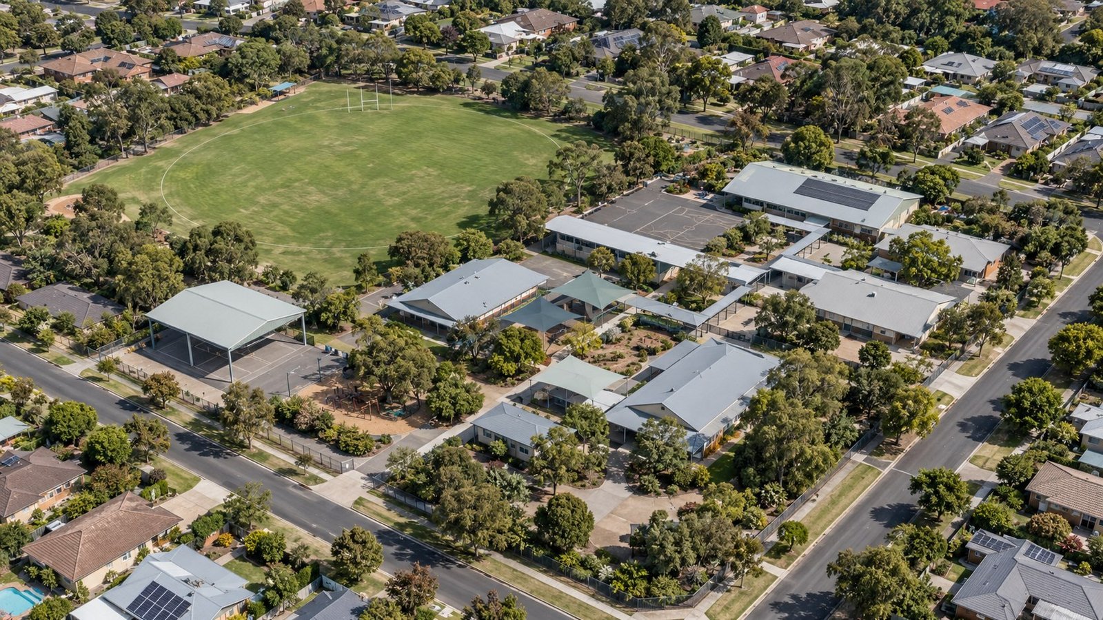 Aerial view of a suburban Australian primary school campus with sports oval surrounded by residential streets