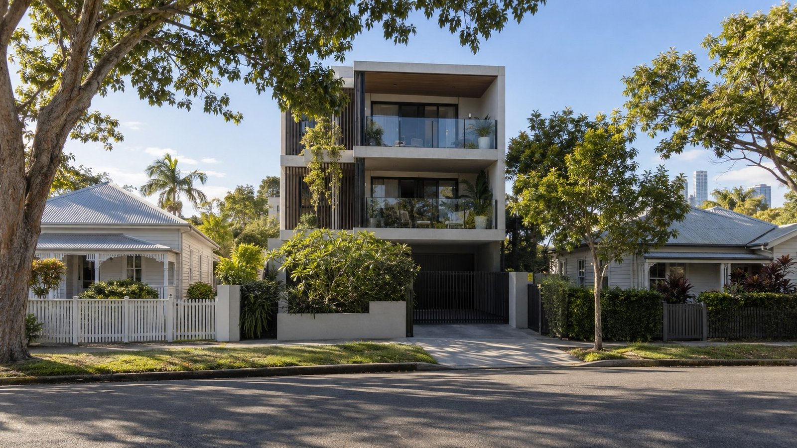 New three-storey apartment building rising between older single-storey cottages on a Brisbane residential street