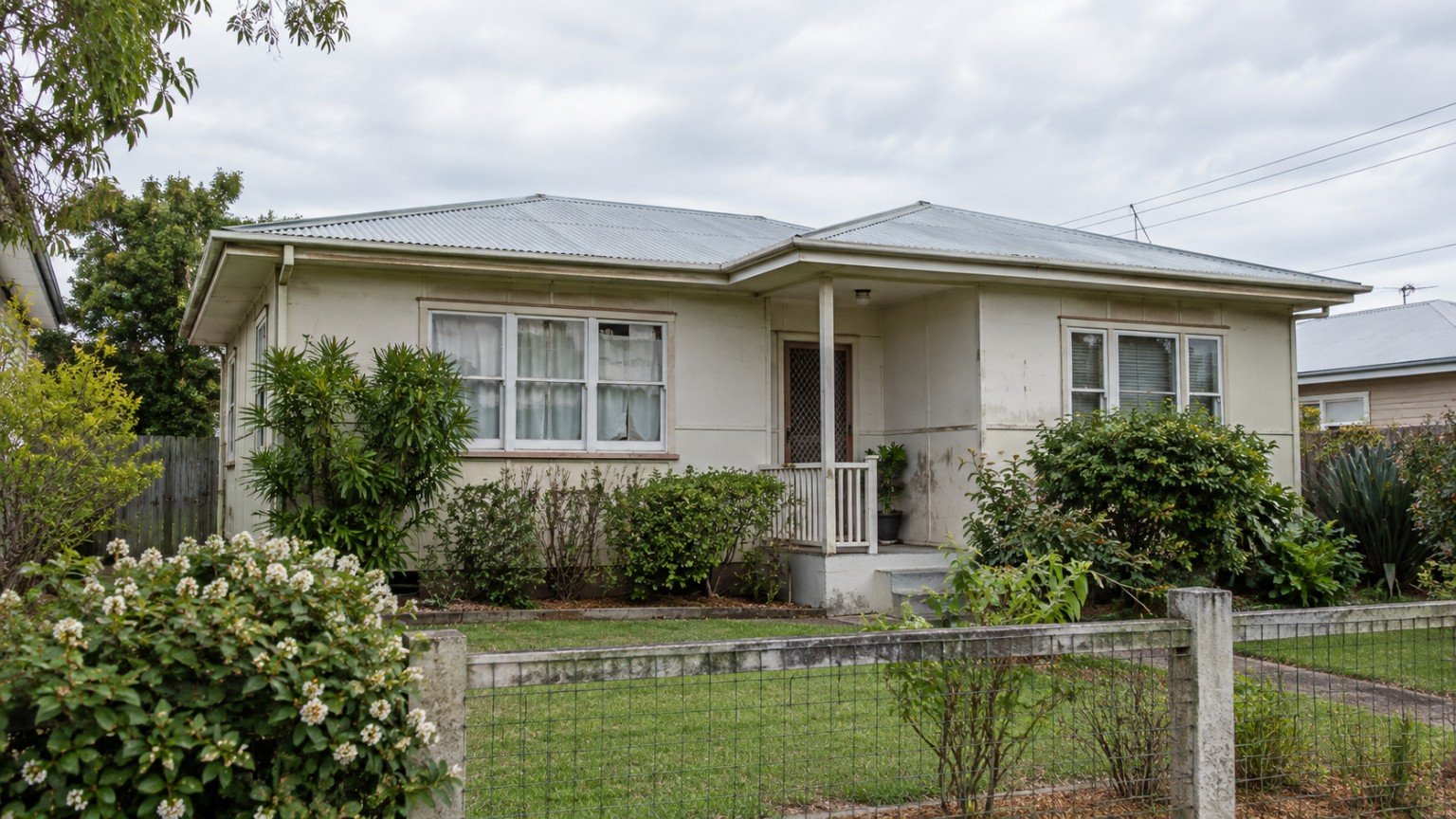 Older Queensland fibro and weatherboard home exterior with weathered wall sheeting