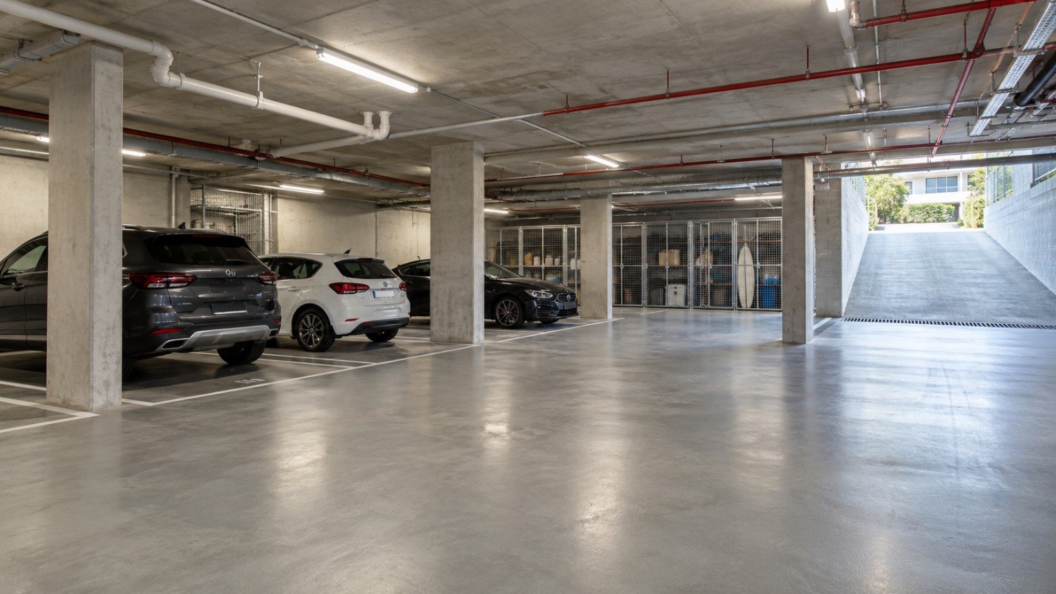 Secure basement car park of a Queensland residential building with marked bays and storage cages