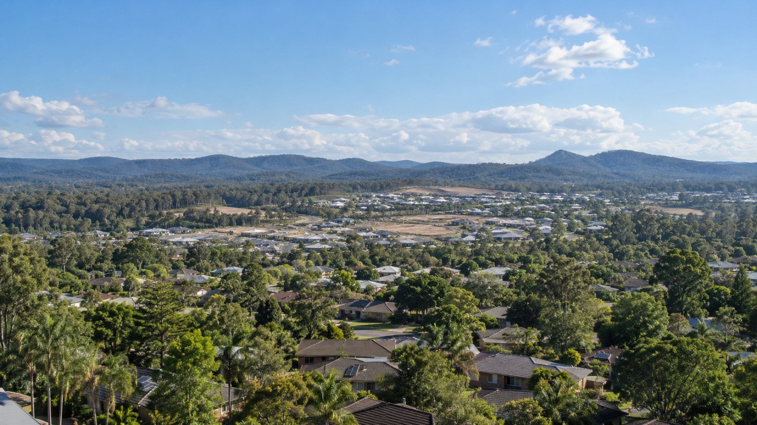 Mixed Logan-region landscape of established homes, new estates and retained bushland corridors