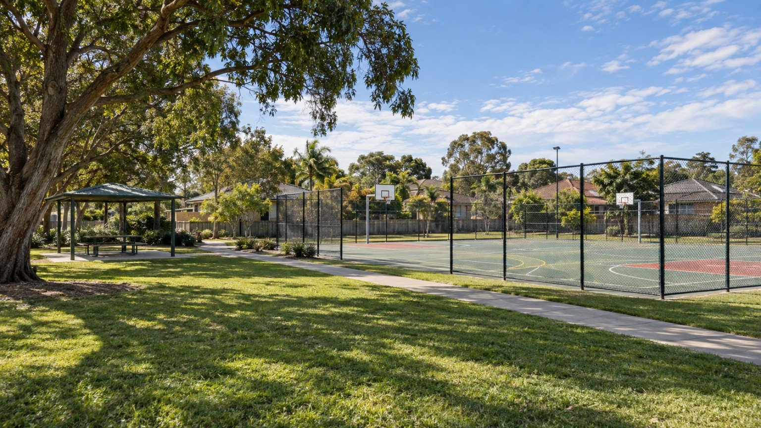 Community park with sports courts and shade trees in a Logan suburb
